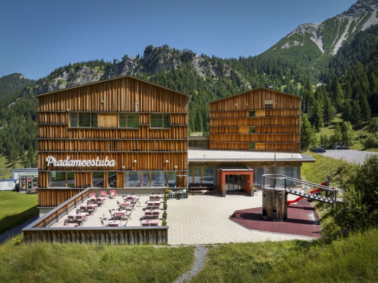 Sie sehen die Sonnenterasse des JUFA Hotels Malbun von aussen.