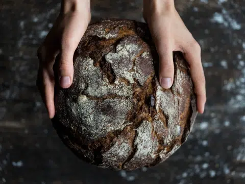 Ein Laib Brot wird gehalten.