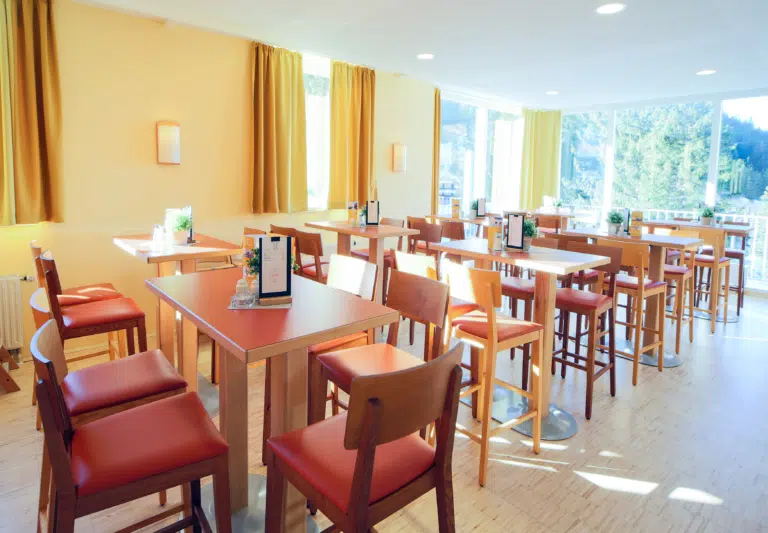 Gemütliches Café mit Fenster im JUFA Hotel Planneralm - Alpin-Resort. Der Ort für erholsamen Familienurlaub und einen unvergesslichen Winter- und Wanderurlaub.