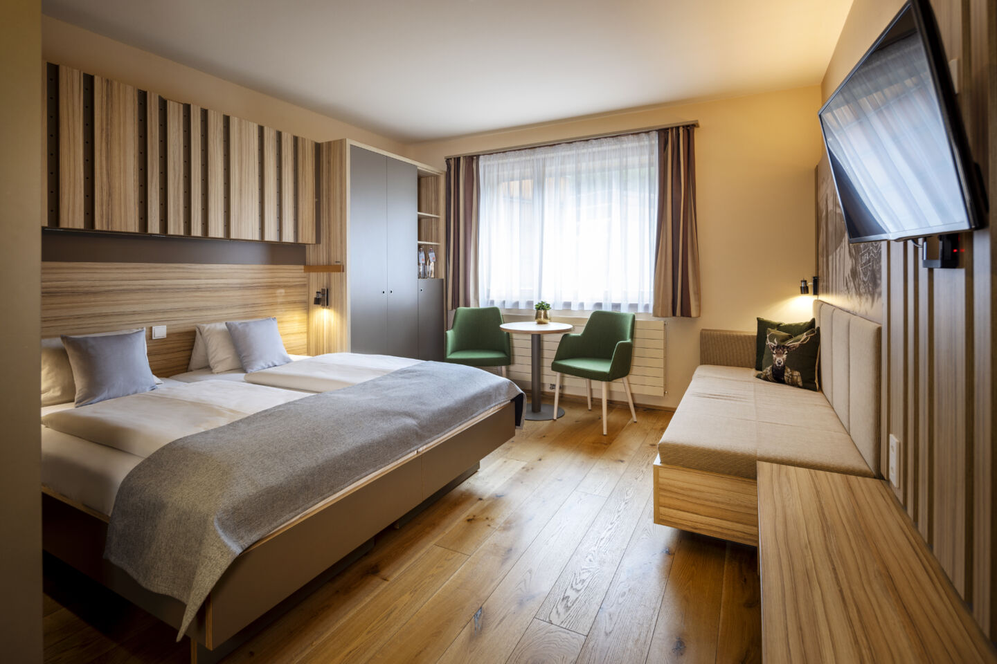 Ihr seht das DZ Doppelzimmer im JUFA Hotel Malbun mit Fernseher und Couch.