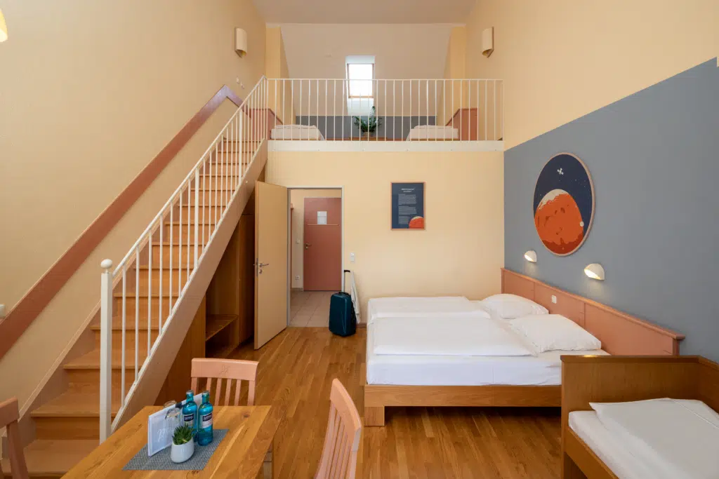 Ihr seht ein Galeriezimmer im JUFA Hotel Nördlingen***. Der Ort für kinderfreundlichen und erlebnisreichen Urlaub für die ganze Familie.