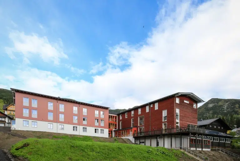 Aussenansicht vom JUFA Hotel Planneralm - Alpin-Resort. JUFA Hotels bieten erholsamen Familienurlaub und einen unvergesslichen Winter- und Wanderurlaub., aussenansicht, garten, gebäude, Hotel, hotelansicht, hotels, Irdning, österreich, Planneralm, sommer, Steiermark, terasse, wiese