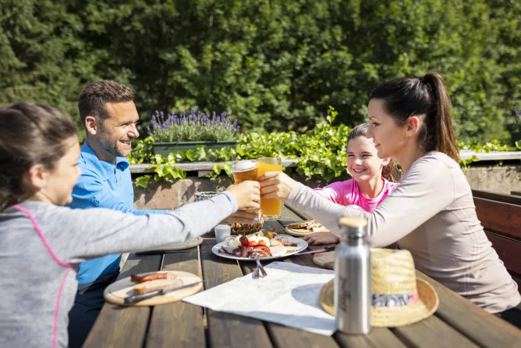 Ihr seht eine Familie bei einer Brettljause. Das JUFA Hotel Eisenerz ist der ideale Ausgangspunkt für Ihren Wander- und Winterurlaub