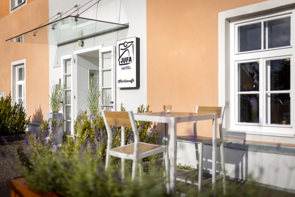 Ihr seht den Eingang bzw. einen Teil des Außenbereichs des Klostercafes vom JUFA HOtel Judenburg. Der Ort für erholsamen Familienurlaub und einen unvergesslichen Winter- und Wanderurlaub.
