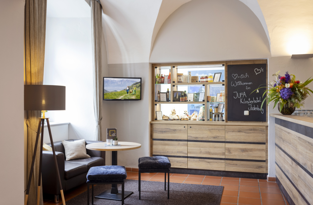 Ihr seht die Rezeption des JUFA Hotel Judenburg im Murtal.