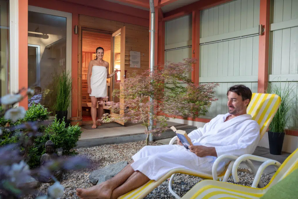 Ihr seht ein Paar beim Entspannen im Wellnessbereich im JUFA Hotel Nördlingen. Der Ort für kinderfreundlichen und erlebnisreichen Urlaub für die ganze Familie.