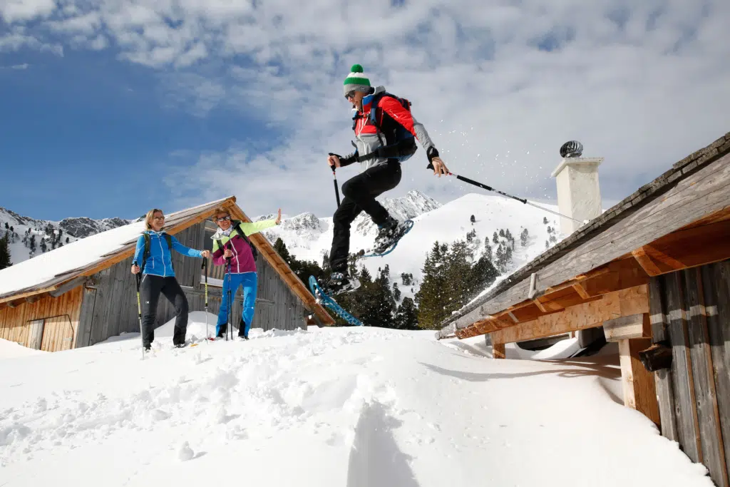 Ihr seht Schneeschuhwander auf einer Berghütte im Murtal im Winter. JUFA Hotels bietet erholsamen Familienurlaub und einen unvergesslichen Winterurlaub.