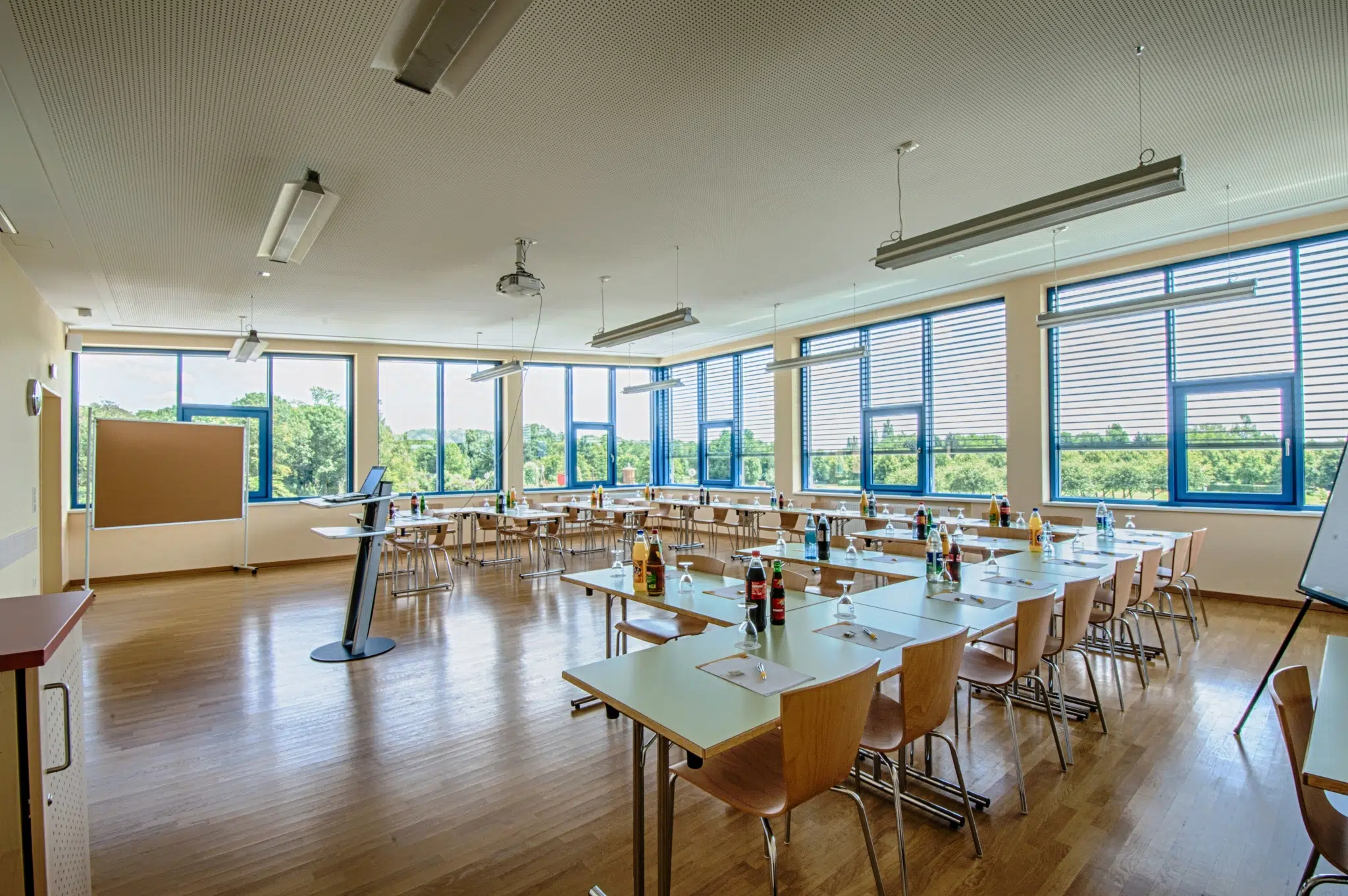 Ihr seht einen gut ausgestatteter Seminarraum mit aufgestellten Tischen in U-Form im JUFA Hotel Jülich***s. Der Ort für kinderfreundlichen und erlebnisreichen Urlaub für die ganze Familie.