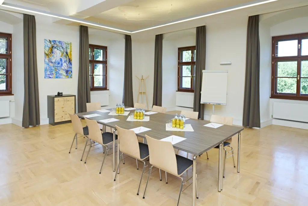 Ihr seht einen gut ausgestatteten Seminarraum mit Seminargetränken im JUFA Hotel Stift Gurk. Der Ort für erfolgreiche und kreative Seminare in abwechslungsreichen Regionen.