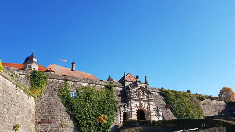 Ihr seht das Tor zum JUFA Hotel Festung Rosenberg Kronach im Sommer. JUFA Hotels bietet kinderfreundlichen und erlebnisreichen Urlaub für die ganze Familie.