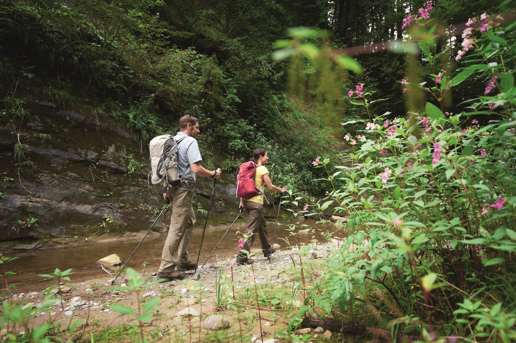 Ihr seht zwei Personen beim Wandern durch die Klamm im Allgäu.