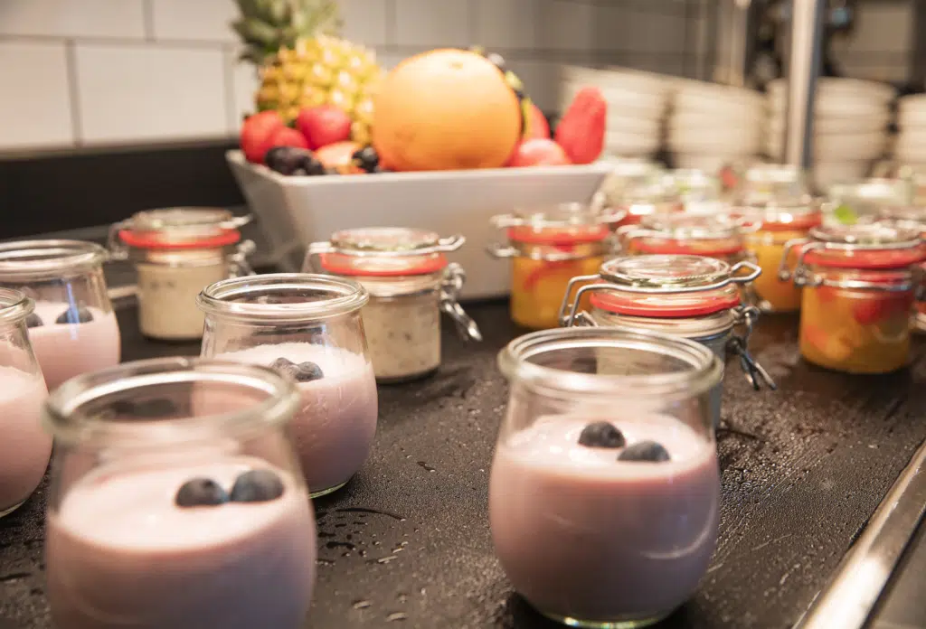 Ihr seht ein Buffet mit Joghurt im JUFA Hotel Salzburg City. Der Ort für erholsamen Familienurlaub und einen unvergesslichen Winter- und Wanderurlaub.