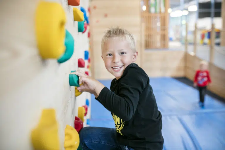 Ihr seht einen Jungen beim Kletternt im Junge im JUFA Hotel Vulkanland – Sport-Resort. Der Ort für erfolgreiches Training in ungezwungener Atmosphäre für Vereine und Teams.