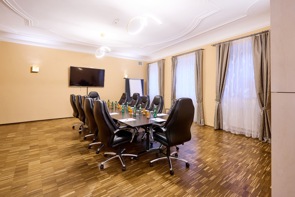 Ihr seht den Boardroom im JUFA Hotel Wien mit Getränken und Schreibunterlagen. Ihr Ohr für inspirierende Seminare in der Stadt Wien.