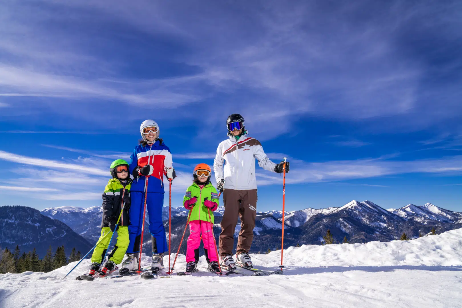 Familie beim Schilauf vor Bergpanorama