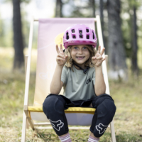 Mädchen mit Fahrradhelm am Klappstuhl