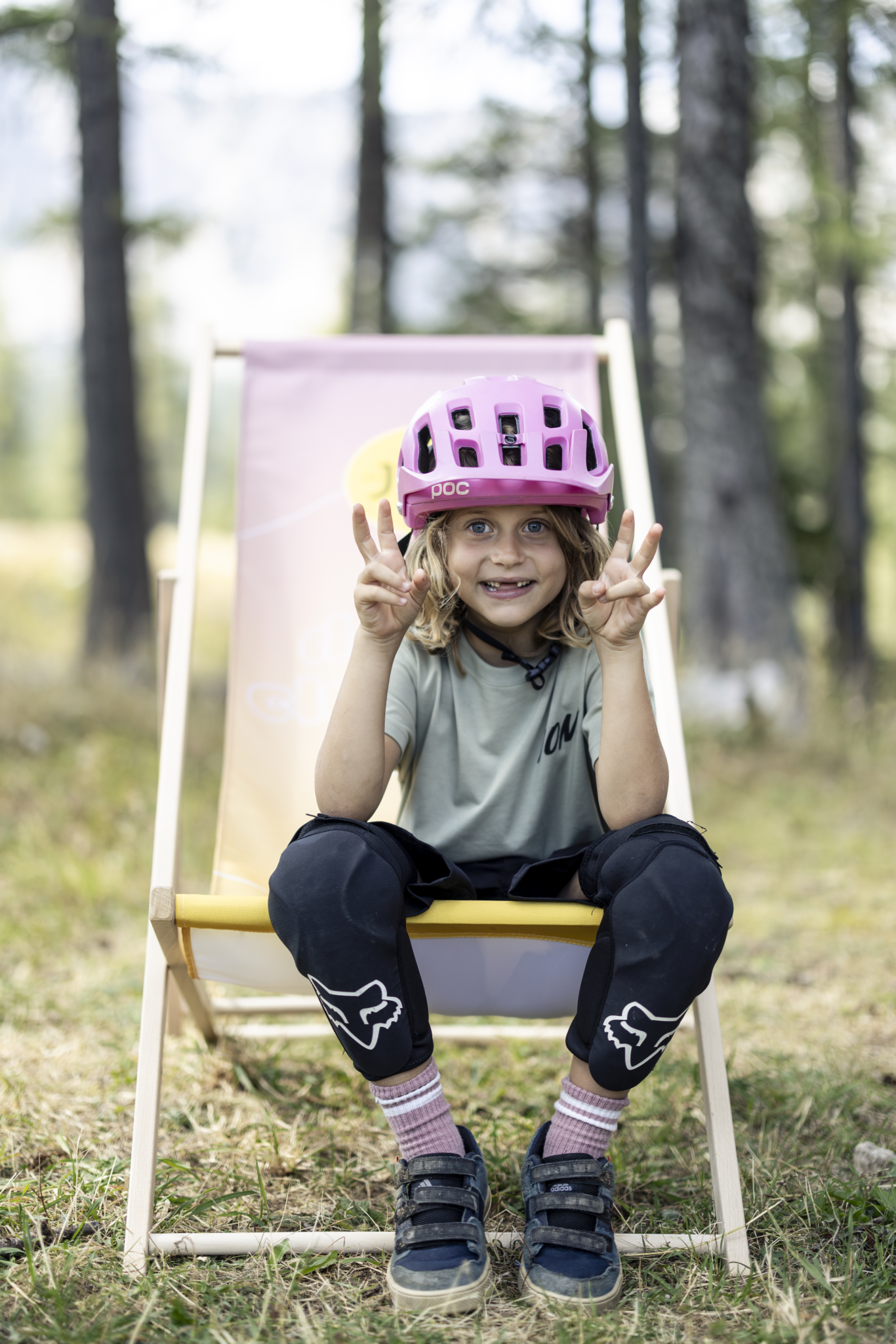 Mädchen mit Fahrradhelm am Klappstuhl