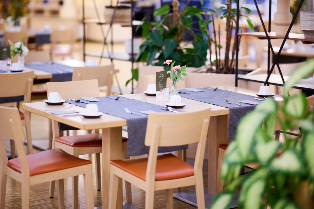 Ihr seht einen gedeckten Tisch im Frühstücksraum vom JUFA Hotel Wien City****. Der Ort für erlebnisreiche Städtetrips und der ideale Platz für eure Seminare.