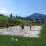 Teens spielen Volleyball am Beachvolleyballplatz beim JUFA Hotel Mariazell Erlaufsee Sport-Resort. Der Ort für erfolgreiches Training in ungezwungener Atmosphäre für Vereine und Teams.