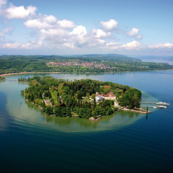 Vogelperspektive von der Insel Mainau am Bodensee mit Landschaft im Sommer in Deutschland. JUFA Hotels bietet Ihnen den Ort für erlebnisreichen Natururlaub für die ganze Familie.