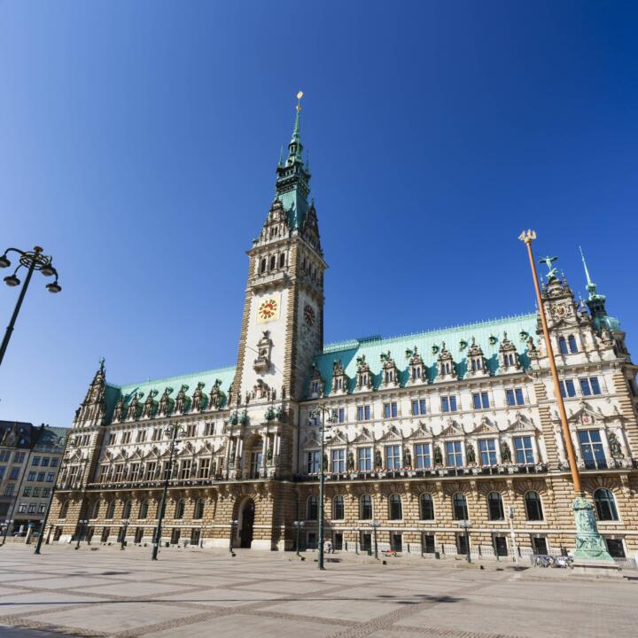 Sie sehen das Rathaus und den Rathausmarkt in Hamburg von vorne. JUFA Hotels bietet erlebnisreichen Städtetrip für die ganze Familie und den idealen Platz für Ihr Seminar.