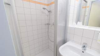 Badezimmer mit Dusche im JUFA Hotel Gitschtal Landerlebnis. Der Ort für kinderfreundlichen und erlebnisreichen Urlaub für die ganze Familie.