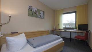 Bett im Einzelzimmer im JUFA Hotel Wangen Sport-Resort mit Fenster. Der Ort für erfolgreiches Training in ungezwungener Atmosphäre für Vereine und Teams.