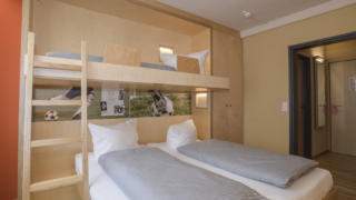 Betten im Familienzimmer medium im JUFA Hotel Wangen Sport-Resort mit Kleiderschrank. Der Ort für erfolgreiches Training in ungezwungener Atmosphäre für Vereine und Teams.