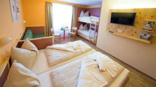 Betten im Familienzimmer large im JUFA Hotel Planneralm Alpin-Resort mit TV. Der Ort für erholsamen Familienurlaub und einen unvergesslichen Winter- und Wanderurlaub.