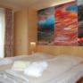 Doppelbett im Doppelzimmer im JUFA Vulkan Thermen-Resort mit Bademantel. Der Ort für erholsamen Thermen- und entspannten Wellnessurlaub für die ganze Familie.