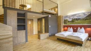 Doppelbett im Galeriezimmer xlarge im JUFA Hotel Pyhrn-Priel mit Vorraum. Der Ort für erfolgreiche und kreative Seminare in abwechslungsreichen Regionen.