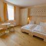 Doppelbett im Hotelzimmer im JUFA Weinviertel Hotel in der Eselsmühle mit Kleiderschrank. Der Ort für erfolgreiche und kreative Seminare in abwechslungsreichen Regionen.