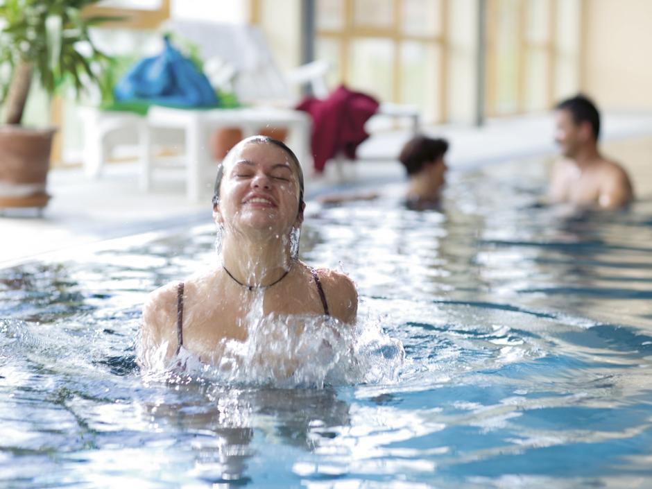 Erwachsene baden im Hallenbad im JUFA Hotel Gans - Sport-Resort. Der Ort für erfolgreiches Training in ungezwungener Atmosphäre für Vereine und Teams.