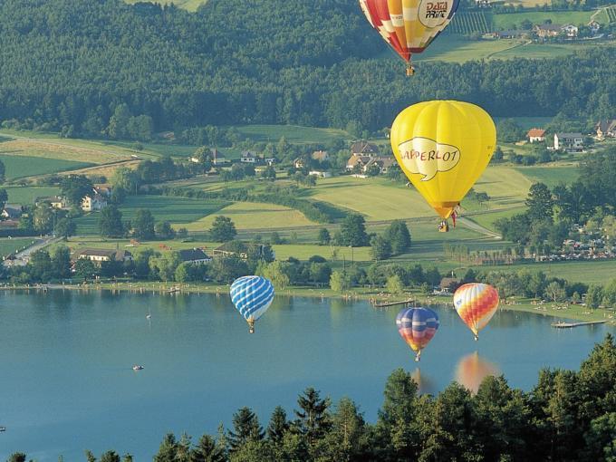Bunte Heißluftballons über dem Stubenbergsee in der Nähe vom JUFA Hotel Stubenbergsee. Der Ort für tollen Sommerurlaub an schönen Seen für die ganze Familie.