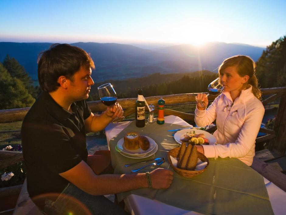 Paar genießt stimmungsvolles Abendessen auf der Tonnerhütte in der Steiermark in der Nähe von JUFA Hotels. Der Ort für erholsamen Familienurlaub und einen unvergesslichen Winter- und Wanderurlaub.