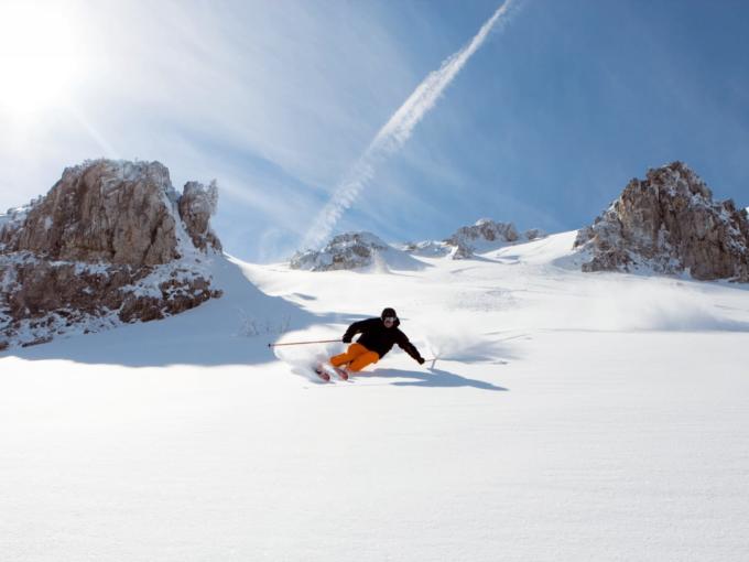 Mann beim Skifahren am Obertauern im Salzburger Land bei Sonnenschein. JUFA Hotels bietet erholsamen Familienurlaub und einen unvergesslichen Winterurlaub.
