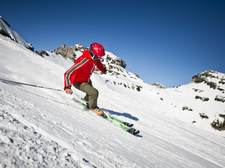 Skifahrer fährt im Skigebiet Loser Sandling im Salzkammergut die Piste herunter in der Nähe von JUFA Hotels. Der Ort für erholsamen Familienurlaub und einen unvergesslichen Winter- und Wanderurlaub.