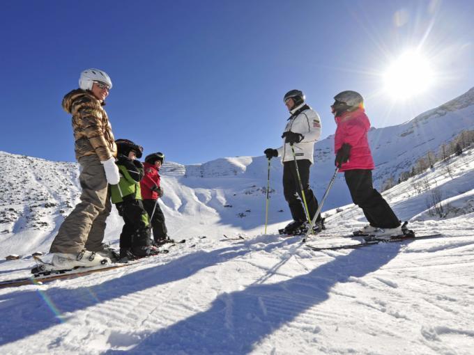 Familie beim Skifahren im Skigebiet Malbun in den Liechtensteiner Alpen in der Nähe vom JUFA Hotel Malbun - Alpin-Resort. Der Ort für erholsamen Familienurlaub und einen unvergesslichen Winterurlaub.