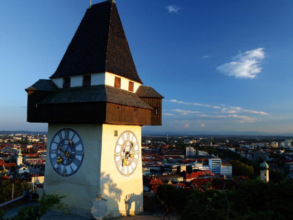 Uhrturm in Graz bei Sonnenschein im Sommer. JUFA Hotels bietet erlebnisreichen Städtetrip für die ganze Familie und den idealen Platz für Ihr Seminar.