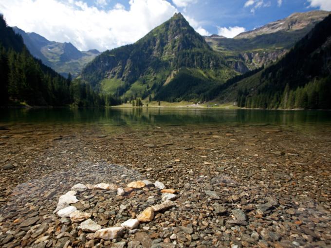 Ein Herz, gestaltet mit Steinen, am Ufer eines Sees im Naturpark Sölktäler in der Region Schladming-Dachstein. JUFA Hotels bietet Ihnen den Ort für erlebnisreichen Natururlaub für die ganze Familie.
