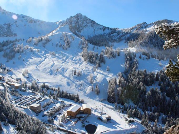 Sie sehen eine Landschaftsbild mit der Hotelansicht des JUFA Hotels Malbun Alpin-Resort aus der Vogelperspektive im Winter mit Schnee. Der Ort für erholsamen Familienurlaub und einen unvergesslichen Winter- und Wanderurlaub.