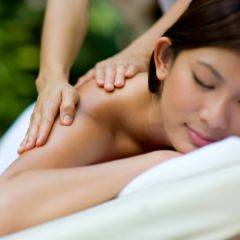 Eine Frau auf einer Massageliege genießt eine entspannende Rückenmassage. JUFA Hotels bietet erholsamen Thermen- und Badespass für die ganze Familie.