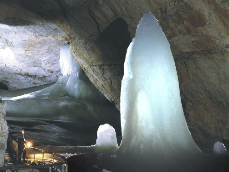 Ein Mann bestaunt eine riesige Eisskulptur in der Dachstein Rieseneishöhle. JUFA Hotels bietet Ihnen den Ort für erlebnisreichen Natururlaub für die ganze Familie.