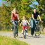 Vater, Mutter und Tochter machen eine Radtour. JUFA Hotels bietet Ihnen den Ort für erlebnisreichen Natururlaub für die ganze Familie.