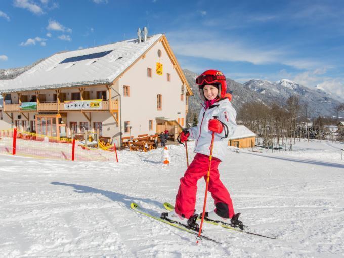 Kind beim Skifahren vorm JUFA Hotel Gitschtal Landerlebnis. Der Ort für erholsamen Familienurlaub und einen unvergesslichen Winterurlaub.