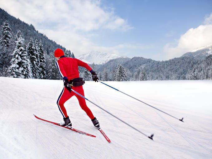 Ein Langläufer skatet auf seinen Langlaufskiern durch eine Winterlandschaft. JUFA Hotels bietet erholsamen Familienurlaub und einen unvergesslichen Winterurlaub.