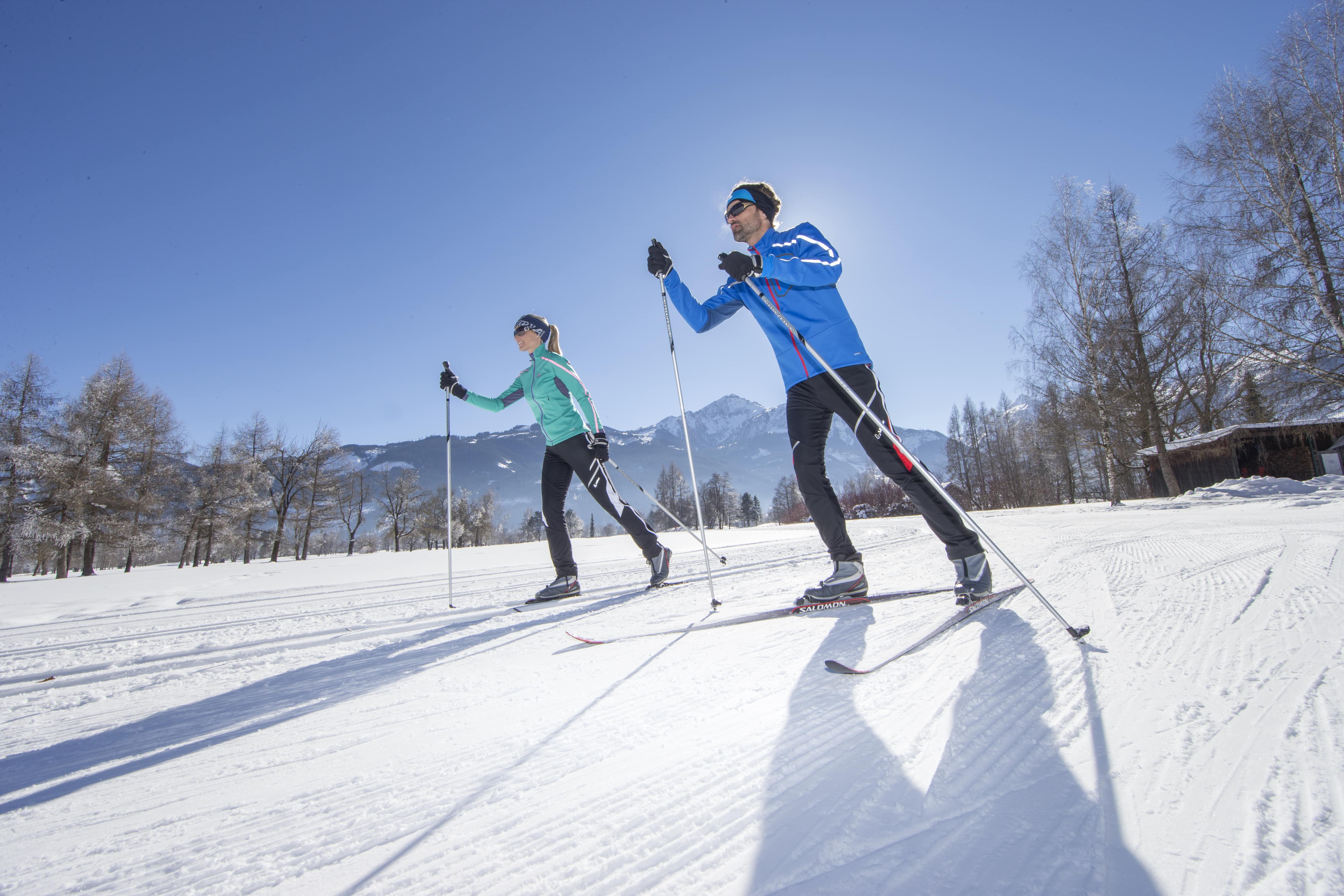Ein Paar beim klassischen Langlaufen und Skating in Zell am See-Kaprun im Salzburger Land. JUFA Hotels bietet erholsamen Familienurlaub und einen unvergesslichen Winterurlaub.