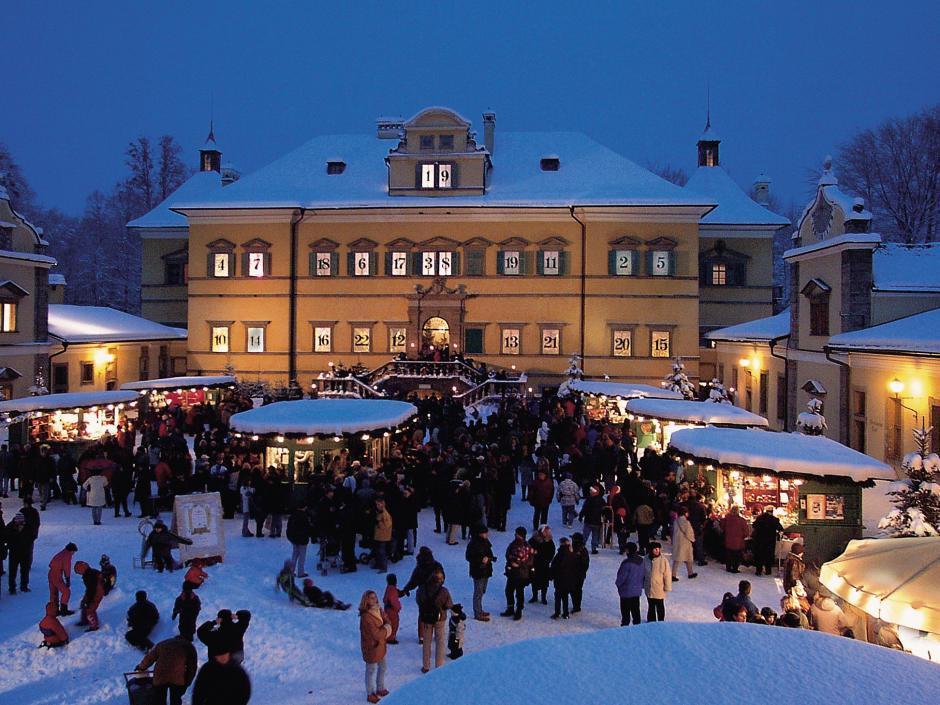 Sie sehen den Weihnachtsmarkt vor dem Schloss Hellbrunn in Salzburg. JUFA Hotels bietet erlebnisreichen Städtetrip für die ganze Familie und den idealen Platz für Ihr Seminar.