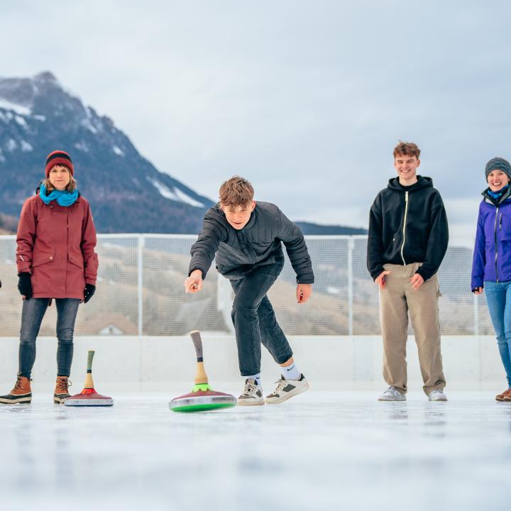 Sie sehen eine Gruppe Jugendlicher beim Eisstockschießen