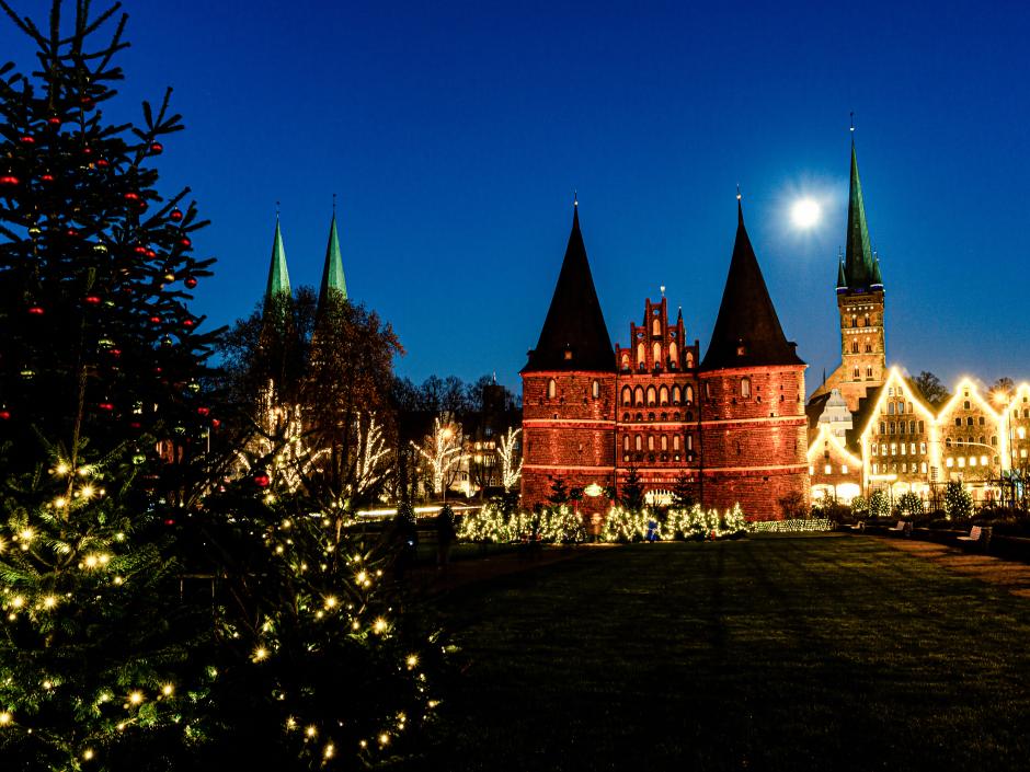 Sie sehen den Lübecker Weihnachtsmarkt am Abend in der Innenstadt.